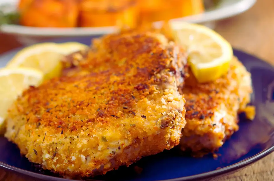 Longhorn Parmesan Crusted Chicken (copycat) with lemon in a blue plate